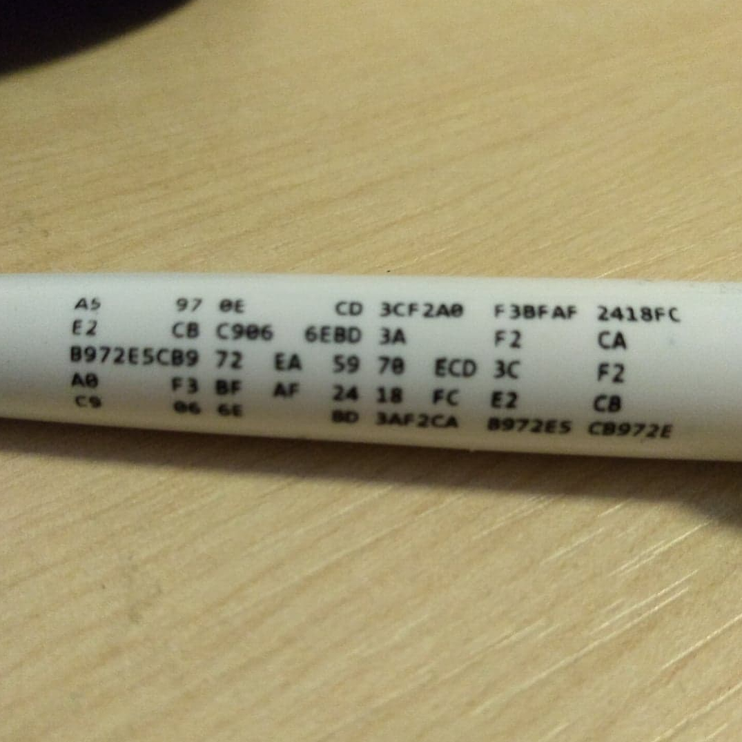 An HMGCC pen with a hexadecimal code printed along the side