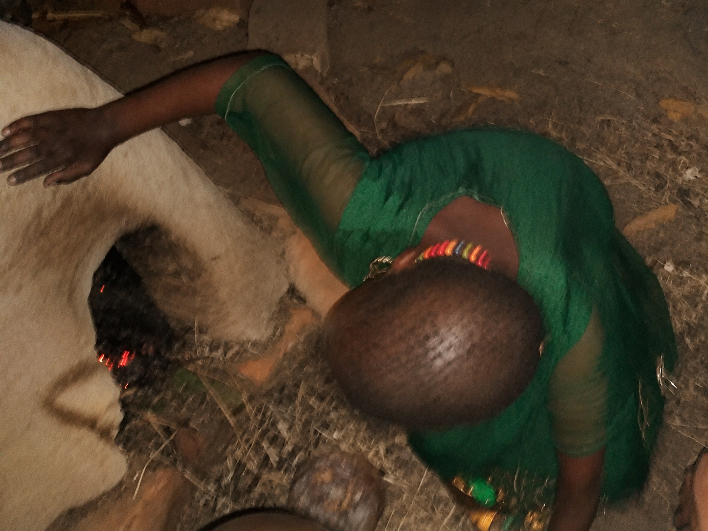 The first small fire being tended inside the earthen oven